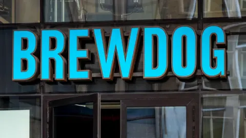 A person entering a Brewdog bar in Tower Hill, London.