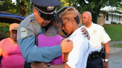 Getty Images Ferguson officer hugs bereaved family