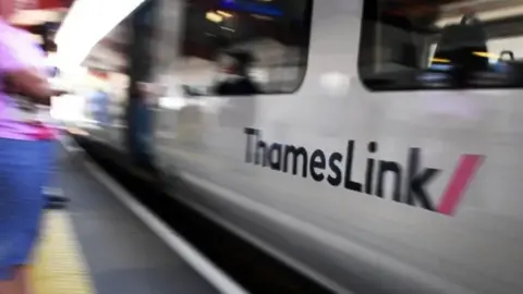 The side of a Thameslink train arriving into a station