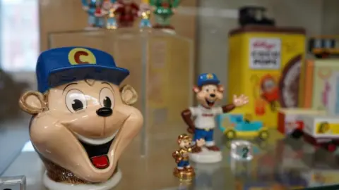 Trafford Council's Local Studies & Archives Memorabilia including the monkey from the Coco Pops box in a cabinet.