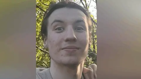 A close-up image of Finbar Sullivan's face. He is a young, slender man with dark hair.