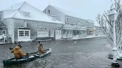 Reuters High School students row a canoe along a road during heavy flooding, in Nantucket, Massachusetts