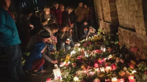 Getty Images Mourners placing flowers and candles outside the synagogue