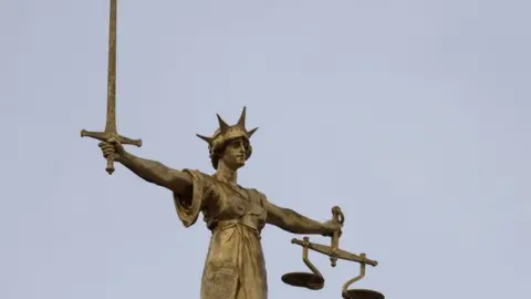 Getty Images A statue of the Scales of Justice stands above the Old Bailey on January 19, 2021 in London, England