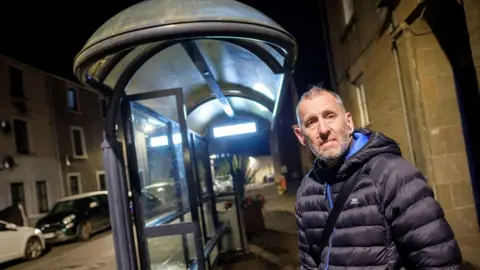 Peter Byrne Civil servant Allan Duffin waiting for his bus in the early morning