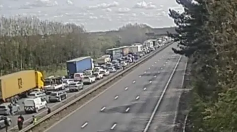 National Highways M1 Junction 20. Cars can be seen at standstill on one side of the road.