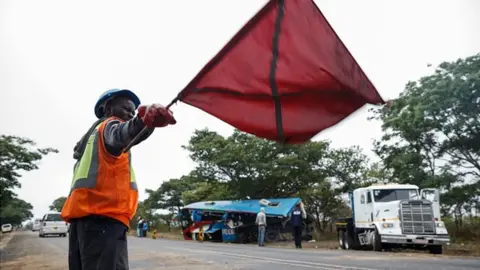 Getty Images A man attends to traffic in Zimbabwe