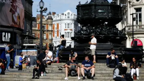 Reuters People sit on steps at Piccadilly Circus, amid the coronavirus disease