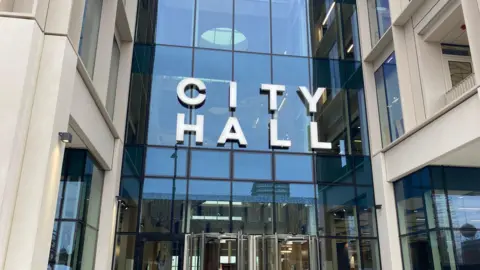 The entrance of Sunderland City Council headquarters. The sign above the glass fronted building reads "city hall".