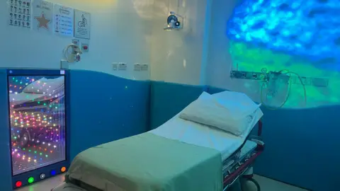 A hospital room with soft lighting and a light tunnel