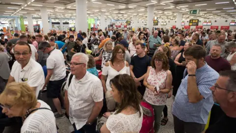 AFP/Getty Images People queuing at an airport