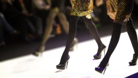 Getty Images Models walking down a catwalk