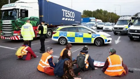 Reuters Insulate Britain activists on the M25 motorway in Thurrock, on 13 October 2021