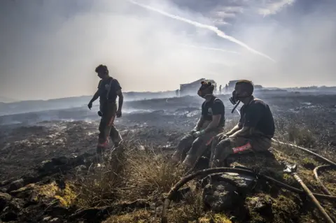 PA Fire fighters tackle the wildfire on Saddleworth Moor on 28 June 2018.