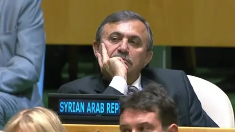 UN / EVN A Syrian envoy to the UN watches Mr Trump's speech, apparently bored, with his head resting on his hand