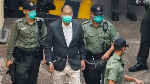 Reuters Media mogul Jimmy Lai Chee-ying, founder of Apple Daily, walks to a prison van to head to court, after being charged under the national security law, in Hong Kong, China December 12, 2020.