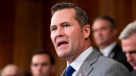 Getty Images Rep Michael Walz is open mouthed in a gray suit with a blue tie