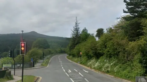 A right junction on a road next to a traffic light