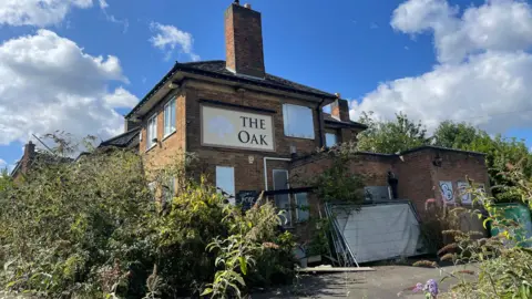 The Oak pub site in Whitwick with overgrown plants all around