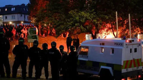Reuters Police officers stand guard next to a police vehicle