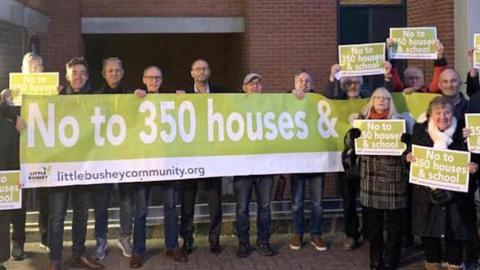 Campaigners holding up a banner ahead of a council meeting