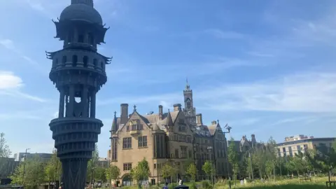 LDRS The Tower of Now - a grey sculpture - with Bradford City Hall in the background