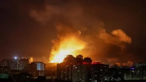 Reuters An explosion of a drone lights up the sky over the city during a Russian drone strike
