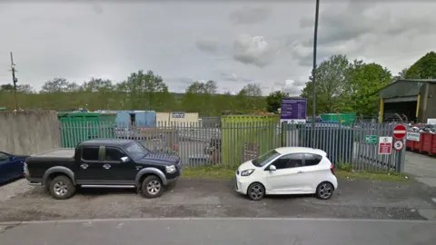 Google Waste recycling centre - industrial site behind metal fencing 