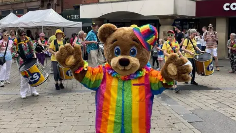 Oldham Council Bear in rainbow suit during pride parade