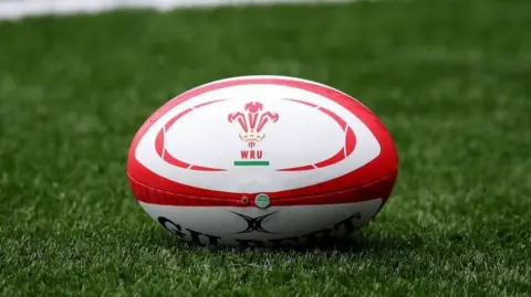 Getty Images A Gilbert rugby ball with the WRU three feathers emblem in the middle on a green pitch