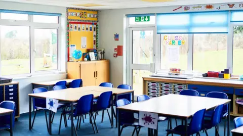 Getty Images An empty primary school classroom with coloured chairs around small tables