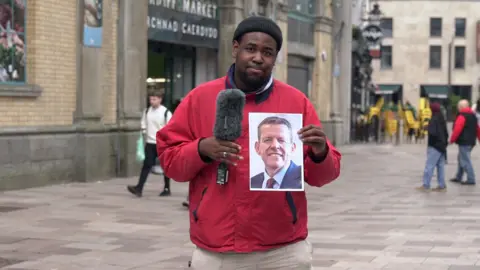 Terel Edmunds holding a picture of Rhun ap Iorwerth