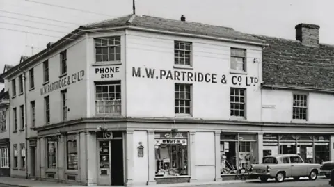 Hadleigh Archive A black and white photo of a building in High Street, Hadleigh, featuring the words M.W Partridge & Co. Ltd.