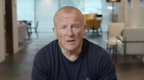 PA Neil Woodford, dressed in black jumper, looks at camera in head and shoulders shot.