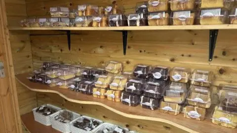 Shelves inside the Capel Cake Shed are filled with packaged cakes, brownies and traybakes.
