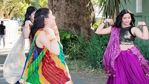 Art Asia Women in traditional South Asian clothing dance outside at a festival. 