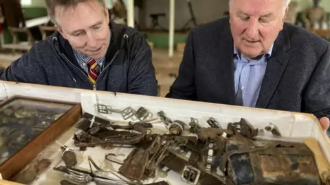Martin Giles/BBC Taff Gillingham and Colin Fakes looking at his grandfather's possessions, found with his body at Roeux in France