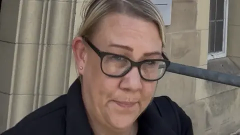 Carla Earnshaw, a woman in her late 30, photographed outside Carlisle Magistrates' Court. She has blonde hair and glasses. 