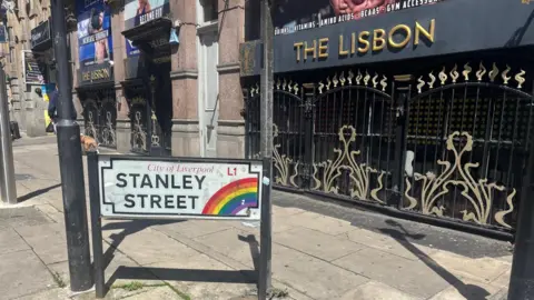 A close-up of Stanley Street's road sign in Liverpool city centre with a rainbow indicating it is part of the Pride Quarter. 