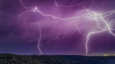 A purple sky filled with lightening