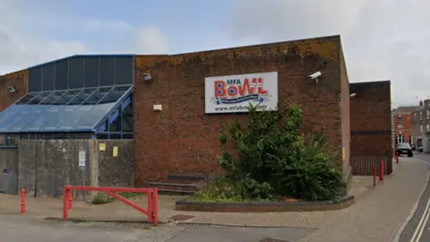 Google The outside of the MFA Bowl building, a square brick building with a sign on the outside reading "MFA Bowl"