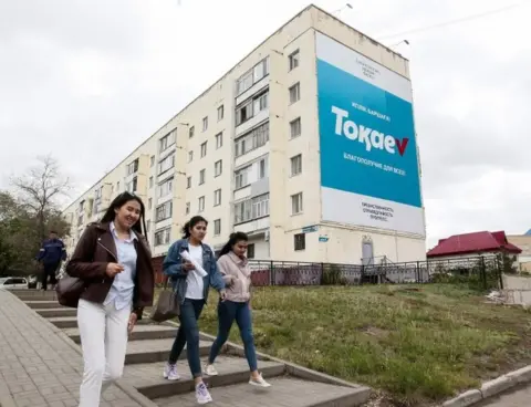 AFP Young women walk past an election campaign billboard for Kazakh President and presidential candidate Kassym-Jomart Tokayev in Nur-Sultan on June 5, 2019, ahead of Kazakhstan"s presidential elections on June 9.