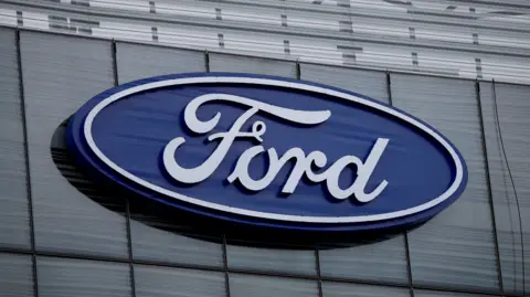 The blue Ford oval logo is displayed on the new Ford World Headquarters in Dearborn, Michigan, U.S. November 16, 2025.