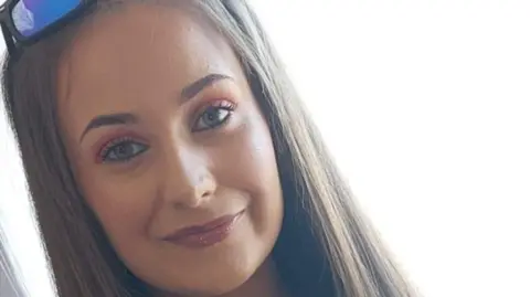 Image of Chloe Mitchell, a woman with blonde hair, who has sunglasses on her head