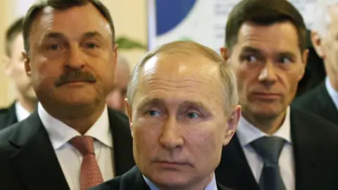 Getty Images Andrey Guryev (left) is pictured with Vladimir Putin at an event in 2020