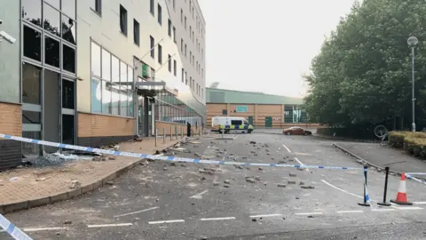 BBC Rubble scattered on the pavement outside the hotel. A police cordon is in place and a police van is parked up outside the hotel