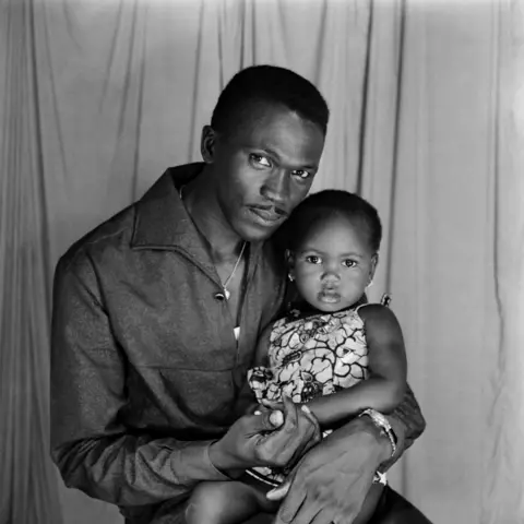 Roger DaSilva/Josef and Anni Albers Foundation A man and baby girl pose for the camera in the photographer's studio.