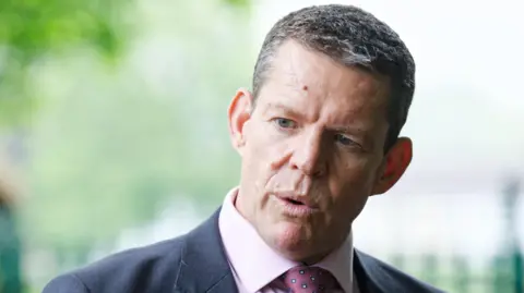 Rhun ap Iorwerth speaking into a camera