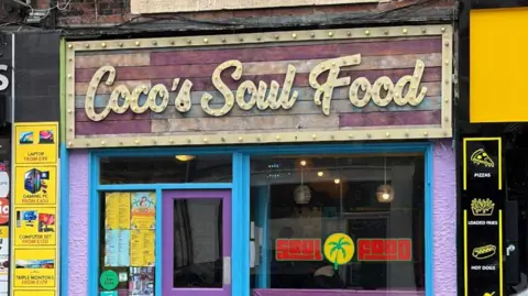 The exterior of Coco's Soul Food is vibrant, and the restaurant sign is written in brown.