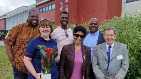 Swansea Bay University Health Board Agnes with her sons Farai, Tendai, and Rugare, and members of staff at the hospital